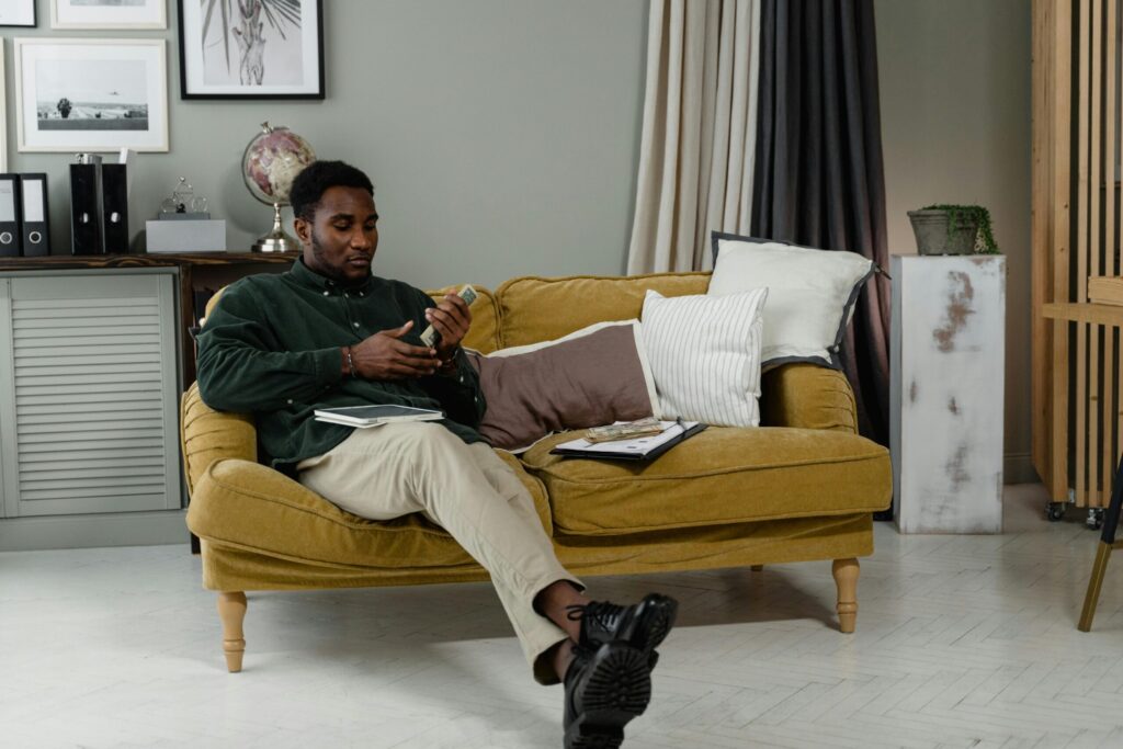 Man on a couch getting word of his income
